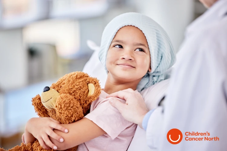 Child in hospital bed with teddy bear