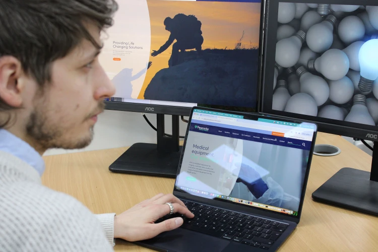 Man siting at desk looking at screens