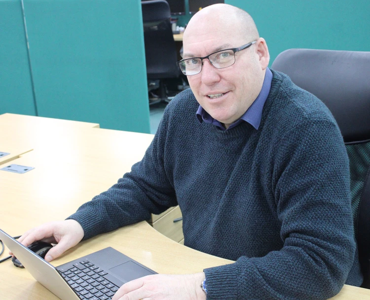 Man sitting at desk over laptop